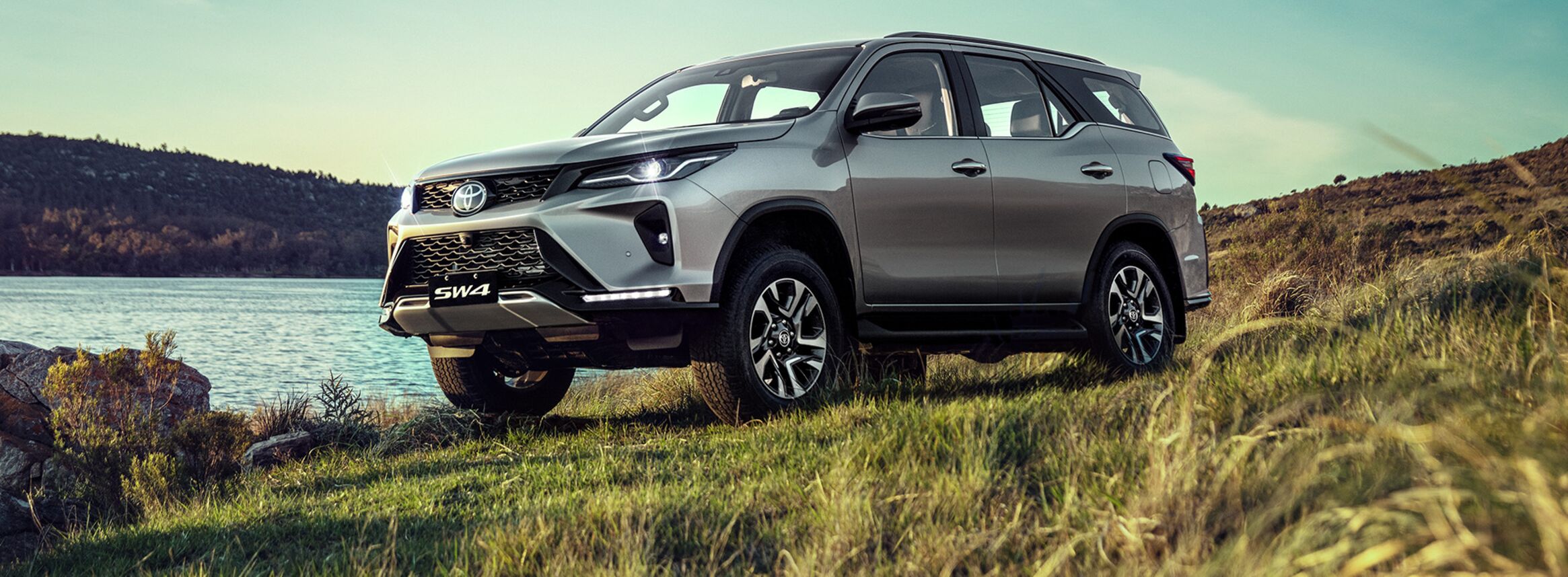 Toyota SW4 Diamond em terreno de grama à beira de um lago